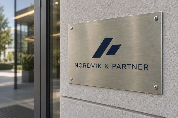 Brushed aluminium company plaque with logo by an office entrance